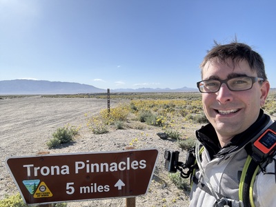 Me in front of a sign pointing to Trona Pinnacles five miles up a gravel road