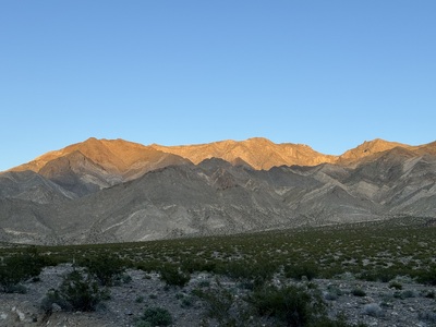 Mountains lit in gold by the setting sun.